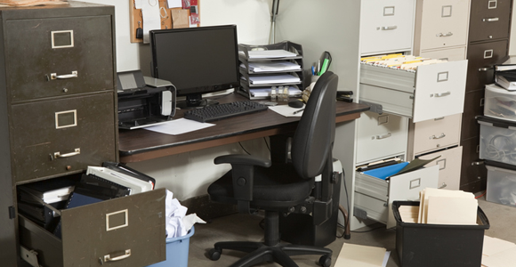 unorganized office space with filing cabinets open and paper everywhere