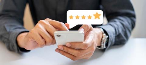 person using smart phone with 5-star bubble above it