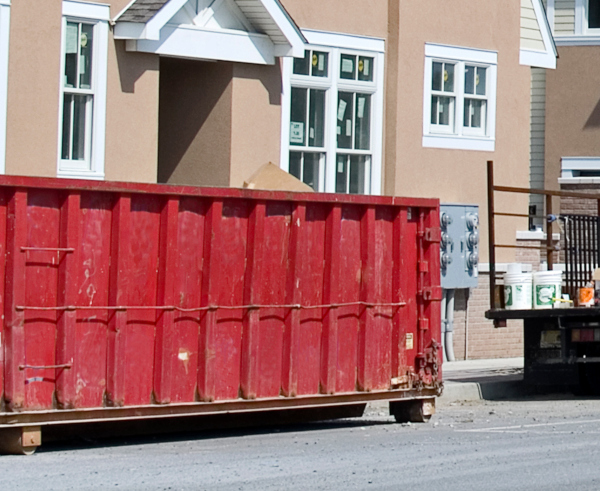 dumpster placed outside apartment building