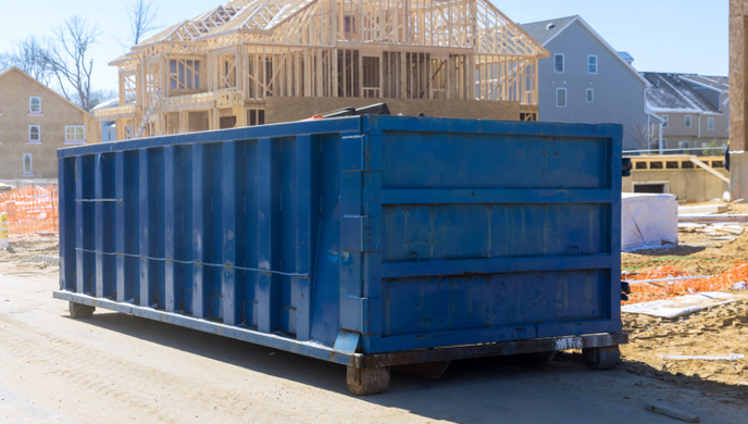 Blue roll-off trash container at residential construction site