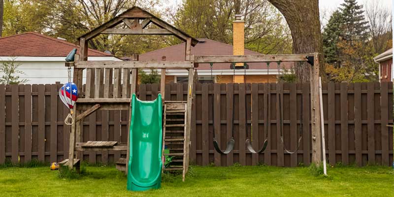 wooden swing set in backyard