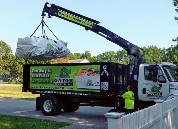 Gator dumpster bag being picked up by garbage truck