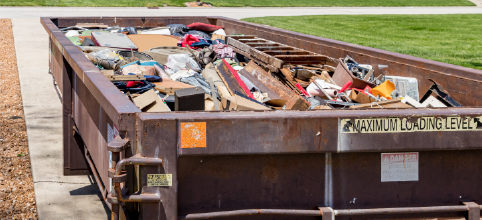 dumpster full of household items sitting in driveway