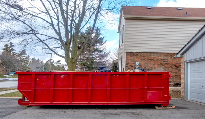 red dumpster sitting in driveway