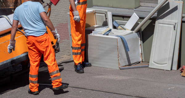 Junk removal crew disposing of construction debris