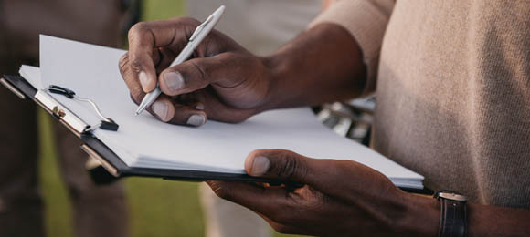 person crossing off checklist on a clipboard