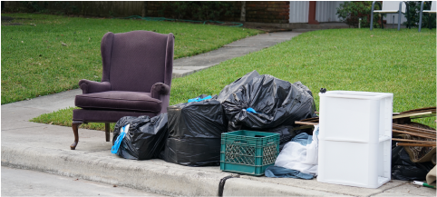 furniture and junk piled by curb