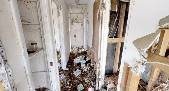 hoarder home with trash covered floors and moldy walls