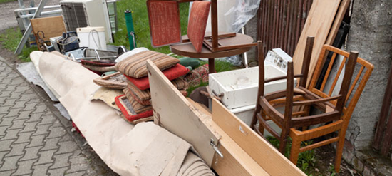 furniture and household debris piled on curb