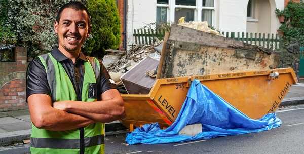 friendly man standing in front of dumpster