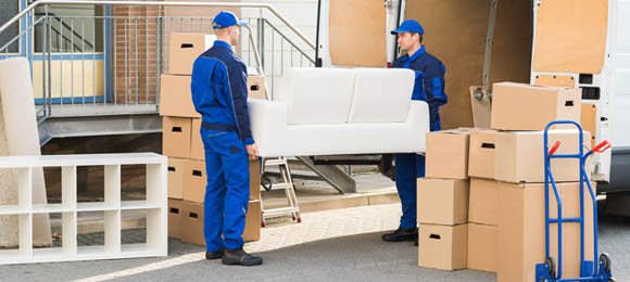 Junk removal crew loading a couch into their hauling vehicle