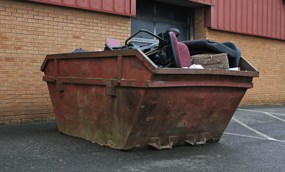 roll-off dumpster full of office furniture