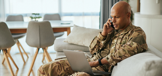 man looking at laptop while on the phone