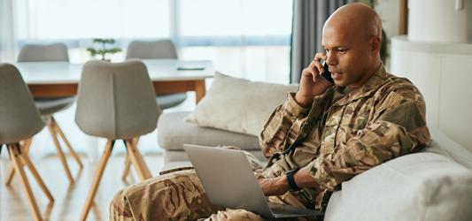 man looking at laptop while on the phone 