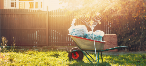 wheelbarrow of yard waste bags in backyard