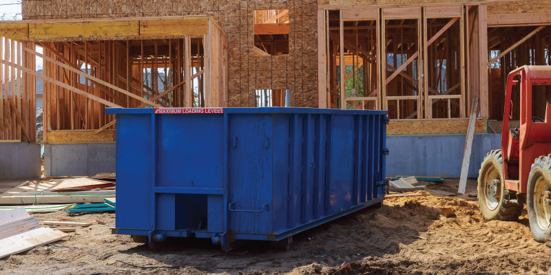 blue dumpster in front of construction site