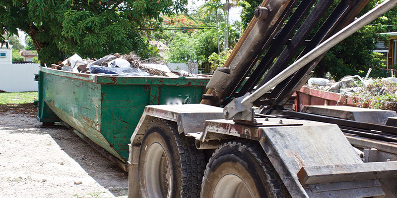 full dumpster being picked up