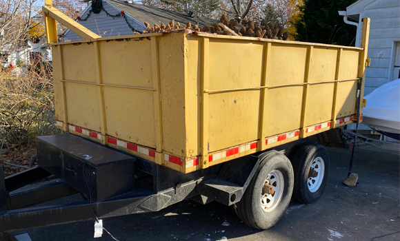 trailer dumpster with rubber wheels in driveway
