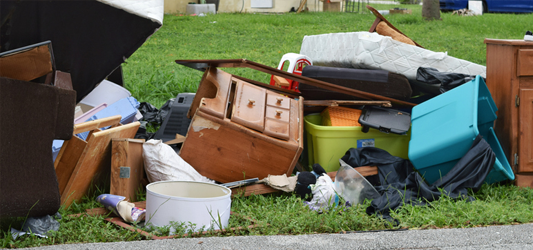 furniture and household junk in a pile at the curb