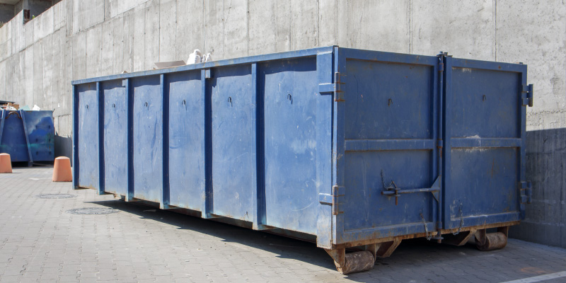 large empty blue roll off dumpster