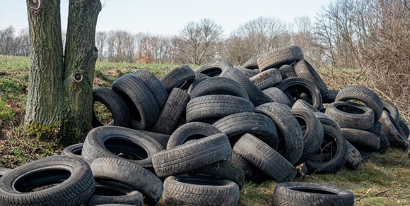 Large pile of old tires in the middle of a yard