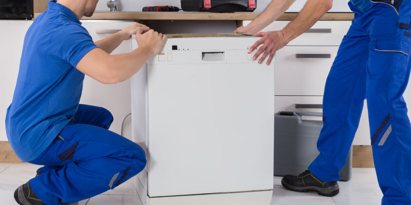 two professionals removing dishwasher