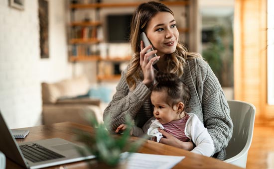 woman on the phone holding a child