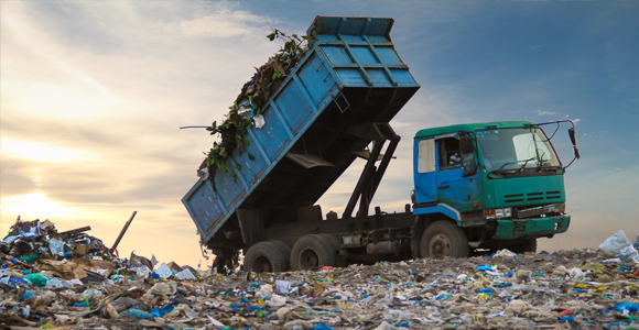 Dump truck unloading waste at landfill