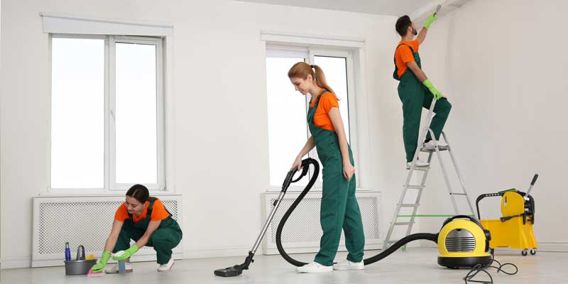 Professionals cleaning up a room post-renovation