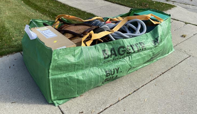 Bagster filled with trash sitting on driveway