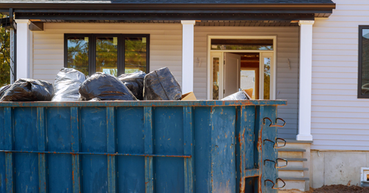 Full roll-off dumpster sitting in front of residential home