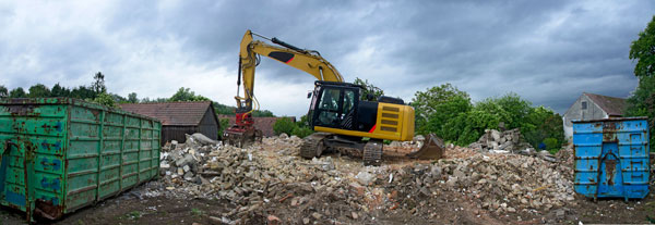 excavator picking up demolition debris