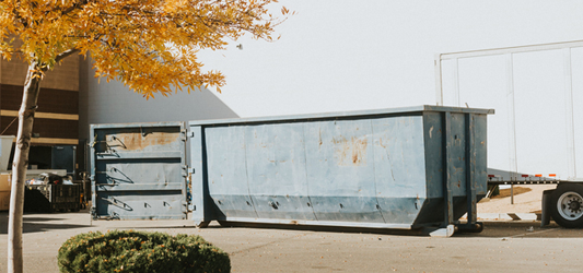 Two empty dumpsters in a parking lot