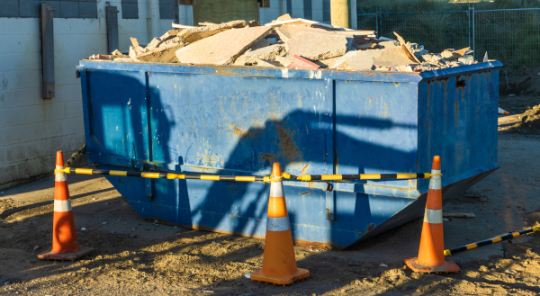 Blue roll-off container filled with construction debris
