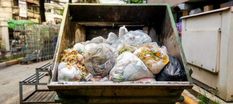 dumpster full of garbage bags