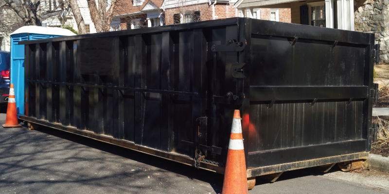 black dumpster in front of house