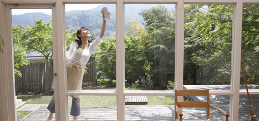 Person cleaning windows outside on sunny day