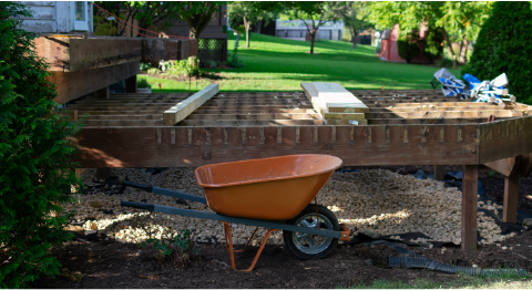 partially demolished wood deck and wheelbarrow