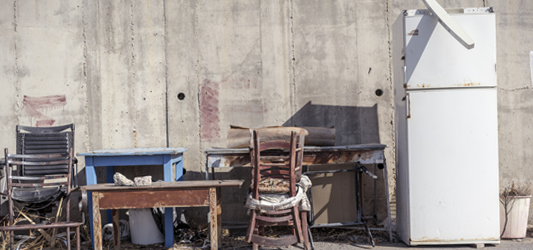 Old, broken furniture and refrigerator outside