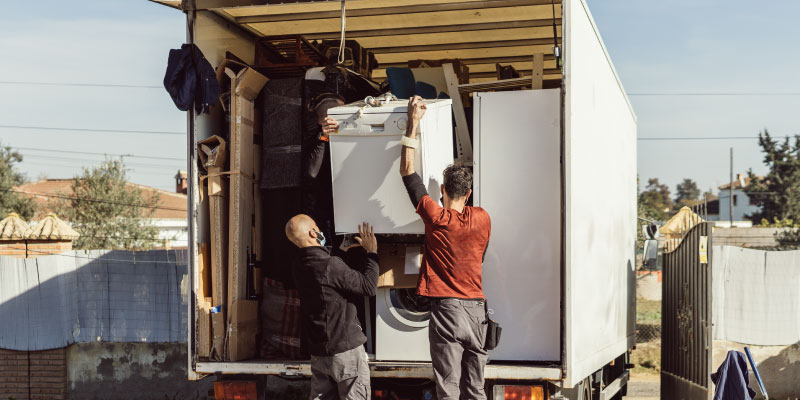 junk removal crew loading appliances onto truck