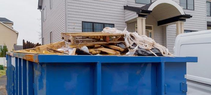 dumpster with household junk and debris in dumpster