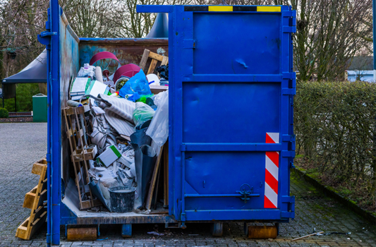 Residential roll-off dumpster in driveway full of household items