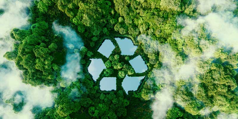 Aerial view of forest with lake in the shape of recycling symbol