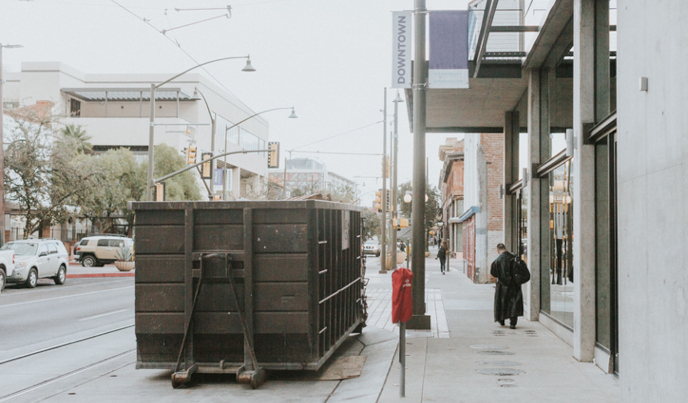 Dumpster placed on side of city street outside a building