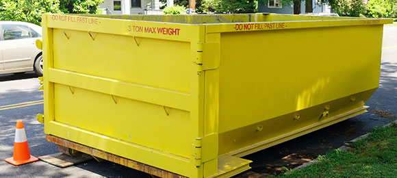 10 yard yellow dumpster placed in street by curb