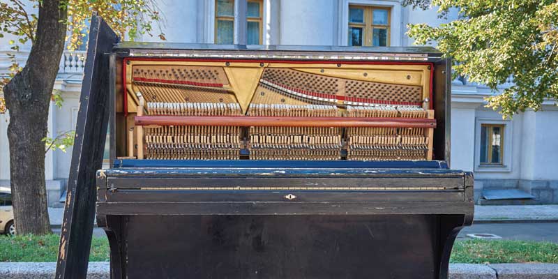 old upright piano at the side of the road