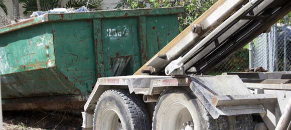 truck loading 20 yard dumpster onto truck