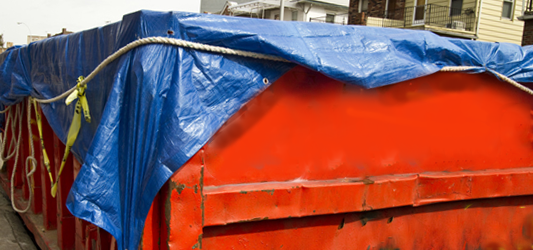 Roll-off dumpster covered with a tarp