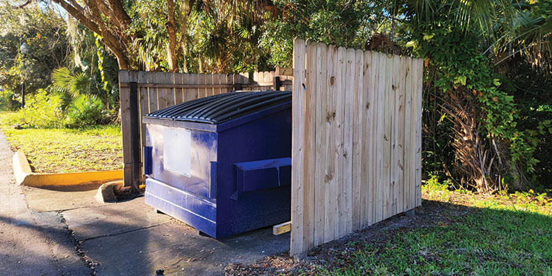 commercial dumpster behind fence