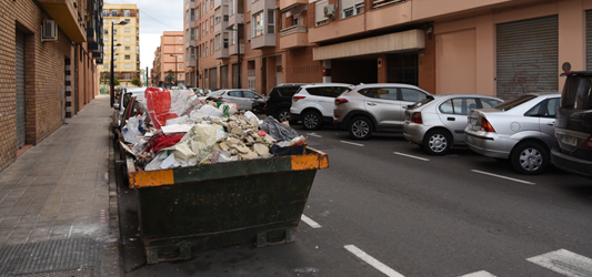 Roll-off dumpster full of construction debris placed in street